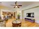 Open concept living room featuring hardwood floors, a ceiling fan, and a kitchen in the background at 3744 E Sierra Madre Ave, Gilbert, AZ 85296