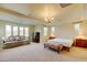 Spacious main bedroom with a sofa, large windows, and a tray ceiling with elegant lighting at 3744 E Sierra Madre Ave, Gilbert, AZ 85296