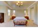 Bright and airy main bedroom with large windows, a tray ceiling, and a classic chandelier at 3744 E Sierra Madre Ave, Gilbert, AZ 85296