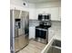 Updated kitchen boasting stainless steel appliances, white cabinets, and attractive countertops at 4038 E Burgess Ln, Phoenix, AZ 85042