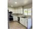 Bright kitchen features white cabinets, stainless steel appliances, and a double sink beneath a large window at 4038 E Burgess Ln, Phoenix, AZ 85042