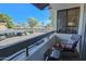 Relaxing balcony view with comfortable rocking chair overlooking the parking and street with lush trees and clear blue sky at 4120 N 78Th St # 217, Scottsdale, AZ 85251