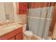 Bathroom with a cherry vanity, a granite countertop and a blue patterned shower curtain at 4120 N 78Th St # 217, Scottsdale, AZ 85251