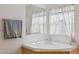 Bathroom corner soaking tub with natural light and elegant fixtures at 43228 N 14Th St, New River, AZ 85087