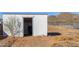 Exterior view of a small storage shed with an open door and natural surroundings at 43228 N 14Th St, New River, AZ 85087