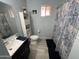 Bathroom featuring a sink, toilet, shower with blue accents and storage cabinet at 4654 S 17Th St, Phoenix, AZ 85040