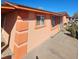 Close up view of a single-story home's exterior elevation with peach paint, decorative trim, and a sidewalk at 4654 S 17Th St, Phoenix, AZ 85040