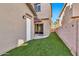 Turf in backyard, with a covered patio and sliding glass door entry into the home at 4669 E Olney Ave, Gilbert, AZ 85234