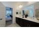 A well-lit bathroom includes a double vanity, a tile floor, and a doorway leading to the main bedroom at 5844 S Tobin --, Mesa, AZ 85212