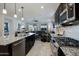 Open kitchen showing stainless steel appliances, dark wood cabinets, granite counters, and barstool seating at 5844 S Tobin --, Mesa, AZ 85212