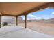 View of the covered back patio looking out onto the large lot surrounded by block wall at 618 E Elm Ln, Avondale, AZ 85323