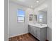 Bright bathroom featuring dual sinks, wood-look floors, and ample lighting at 618 E Elm Ln, Avondale, AZ 85323