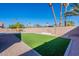 Lush backyard featuring artificial turf, a garden bed, and desert landscaping with palm trees creating a serene outdoor space at 630 W Madero Ave, Mesa, AZ 85210