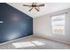 Bedroom with a ceiling fan and a blue accent wall, offering a comfortable space at 630 W Madero Ave, Mesa, AZ 85210