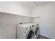 Functional laundry room featuring modern washer and dryer units with a storage shelf above at 630 W Madero Ave, Mesa, AZ 85210