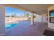 Covered patio overlooks a sparkling pool and green turf, providing a relaxing and inviting outdoor living area at 630 W Madero Ave, Mesa, AZ 85210