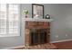 Close-up of brick fireplace with wood mantel, and tulip floral arrangement at 6834 S Dennis Dr, Tempe, AZ 85283