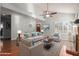 Bright living room featuring hardwood floors, fireplace, fan and large windows with shutter-style blinds at 6834 S Dennis Dr, Tempe, AZ 85283