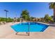 Bright blue community pool with lounge chairs and shade structures offers a refreshing retreat at 6834 S Dennis Dr, Tempe, AZ 85283