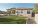 Manicured backyard featuring artificial turf and covered patio, perfect for outdoor entertaining and relaxation at 7355 W Red Hawk Dr, Peoria, AZ 85383