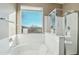 Bright, spacious bathroom features a jacuzzi tub, glass-enclosed shower, and expansive window at 7355 W Red Hawk Dr, Peoria, AZ 85383