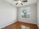 Cozy bedroom with hardwood floors, a ceiling fan, and a view of the outdoors through the window at 7355 W Red Hawk Dr, Peoria, AZ 85383