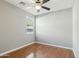 Cozy bedroom with wood floors, ceiling fan, and a window with natural light at 7355 W Red Hawk Dr, Peoria, AZ 85383