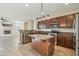 Open concept kitchen with stainless steel appliances, granite counters, tile flooring, and view of the living room at 7355 W Red Hawk Dr, Peoria, AZ 85383