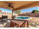 Inviting backyard featuring a covered patio, outdoor dining area, and sparkling pool at 8029 W Whyman Ave, Phoenix, AZ 85043