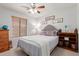 Cozy bedroom featuring a ceiling fan, window with blinds, and comfortable furnishings at 8029 W Whyman Ave, Phoenix, AZ 85043