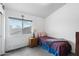 Bright bedroom featuring a single bed, nightstand, and view through a large window at 827 W Kesler Ln, Chandler, AZ 85225