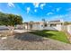 Backyard featuring desert landscaping, a grass patch, patio, and a white house with solar panels on a sunny day at 8443 E Sheridan St, Scottsdale, AZ 85257