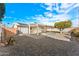 A backyard with a concrete patio under a pergola, desert landscaping, and a white house against a blue sky at 8443 E Sheridan St, Scottsdale, AZ 85257