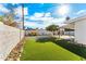 Backyard featuring desert landscaping, a grass patch, patio, and a white house on a sunny day at 8443 E Sheridan St, Scottsdale, AZ 85257