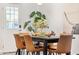 Dining room with a black table, four tan leather chairs, and a Monstera plant near a glass door at 8443 E Sheridan St, Scottsdale, AZ 85257