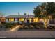 Charming single-story home with a well-manicured front yard and desert landscaping at dusk at 8443 E Sheridan St, Scottsdale, AZ 85257