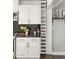 A kitchen featuring white cabinets, stainless steel appliances, a black countertop, and a built-in wine rack at 8443 E Sheridan St, Scottsdale, AZ 85257