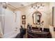 Elegant bathroom with a dark vanity, decorative mirror, and tiled shower-tub, creating a functional space at 9130 E Crystal Dr, Sun Lakes, AZ 85248