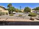 Inviting backyard features desert landscaping, swaying palm trees, and comfortable hammock at 9238 W Behrend Dr, Peoria, AZ 85382