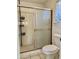 Close up of bathroom shower with sliding doors and built-in shelving and toilet at 9238 W Behrend Dr, Peoria, AZ 85382