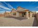 Backyard view of covered patio and gravel landscaping, with stucco home and dark trim at 9716 E Resistance Ave, Mesa, AZ 85212