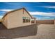 View of the back of the house showing the gravel landscaping, stucco, and dark trim at 9716 E Resistance Ave, Mesa, AZ 85212