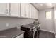 Functional laundry room featuring modern appliances, lots of cabinets, and a countertop at 9716 E Resistance Ave, Mesa, AZ 85212