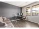 Living room with a dark gray accent wall and a desk in front of two bright windows at 9716 E Resistance Ave, Mesa, AZ 85212