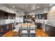 Spacious kitchen featuring dark wood cabinets, stainless steel appliances, and a granite island with bar seating at 9887 E Palo Brea Dr, Scottsdale, AZ 85262