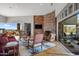 Elegant living room with stone fireplace, hardwood floors, and scenic views of the surrounding landscape at 9887 E Palo Brea Dr, Scottsdale, AZ 85262