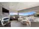 Open living room with stone fireplace and scenic desert views through large windows at 9887 E Palo Brea Dr, Scottsdale, AZ 85262