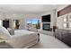 Bright main bedroom with a fireplace, TV and large windows overlooking the desert landscape at 9887 E Palo Brea Dr, Scottsdale, AZ 85262