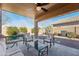 Serene covered patio featuring comfortable seating, a view of the pool, and a backdrop of lush desert landscaping at 1013 S Hazel Ct, Gilbert, AZ 85296