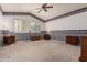 Bedroom features neutral carpet, decorative wallpaper, and window shutters for natural light at 10901 E Sunnydale Dr, Sun Lakes, AZ 85248